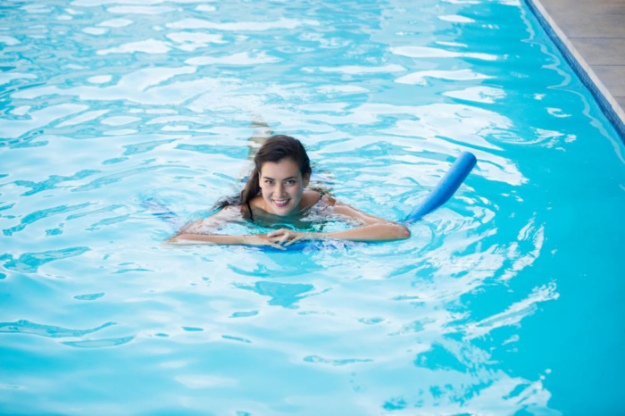 a young woman swimming with an inflatable tube in the pool